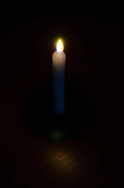 High burning candle on a black background — Stock Photo, Image