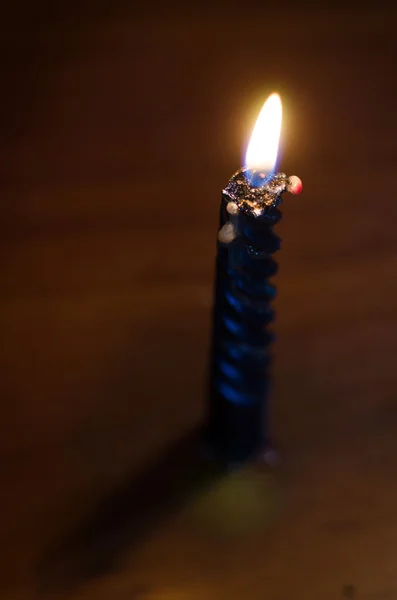 Высокая горящая свеча на черном фоне — стоковое фото