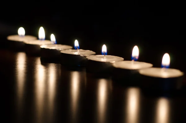 Line of burning candles on black background — Stock Photo, Image