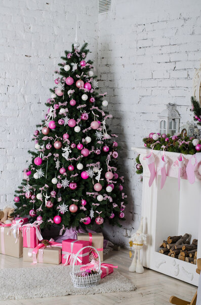 Tree with pink ornaments near the fireplace