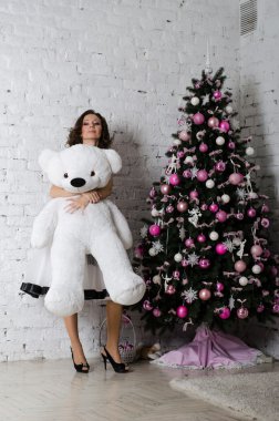 Bir Noel ağacı yakınındaki bir yumuşak oyuncak ile güzel kız