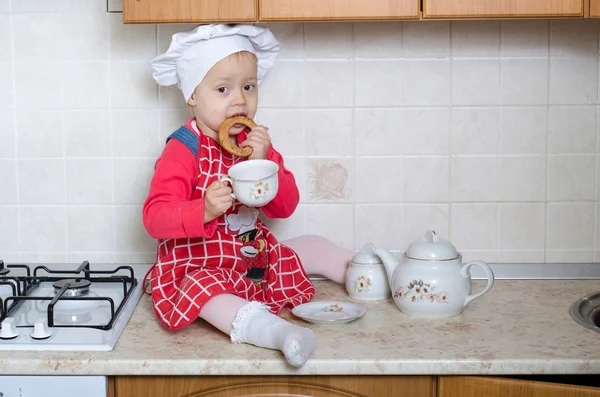 Little baker drinking tea with bagels — Stock Photo, Image