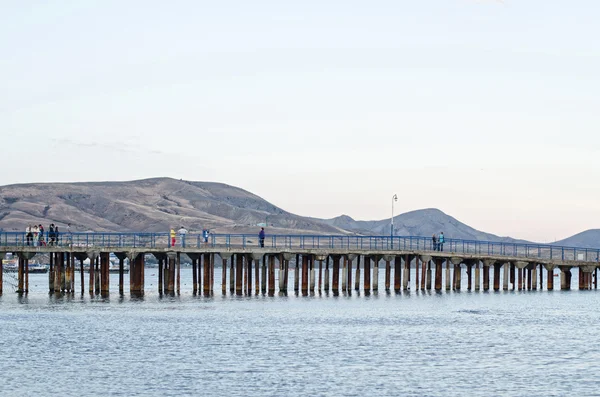 Pier on black sea, mountains in the background — Stock Photo, Image