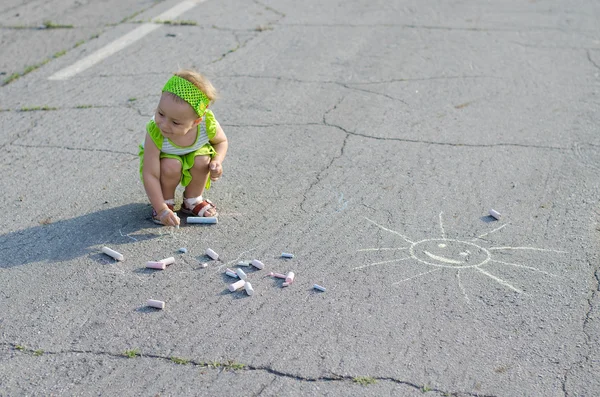 Niña dibuja una tiza en asfalto — Foto de Stock