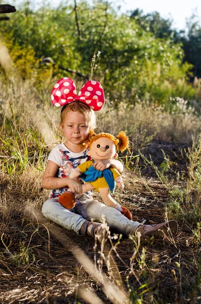 Foto de una niña con una muñeca en las manos . — Foto de Stock