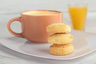 Kahve ve portakal suyu ve üç küçük kurabiye.