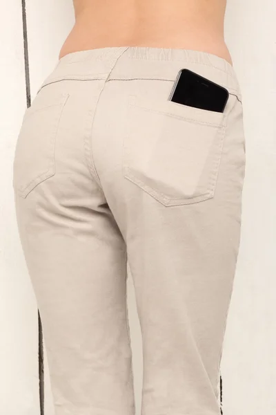 Smart phone in a pocket pants, beautiful girl with sexy booty on — Stock Photo, Image