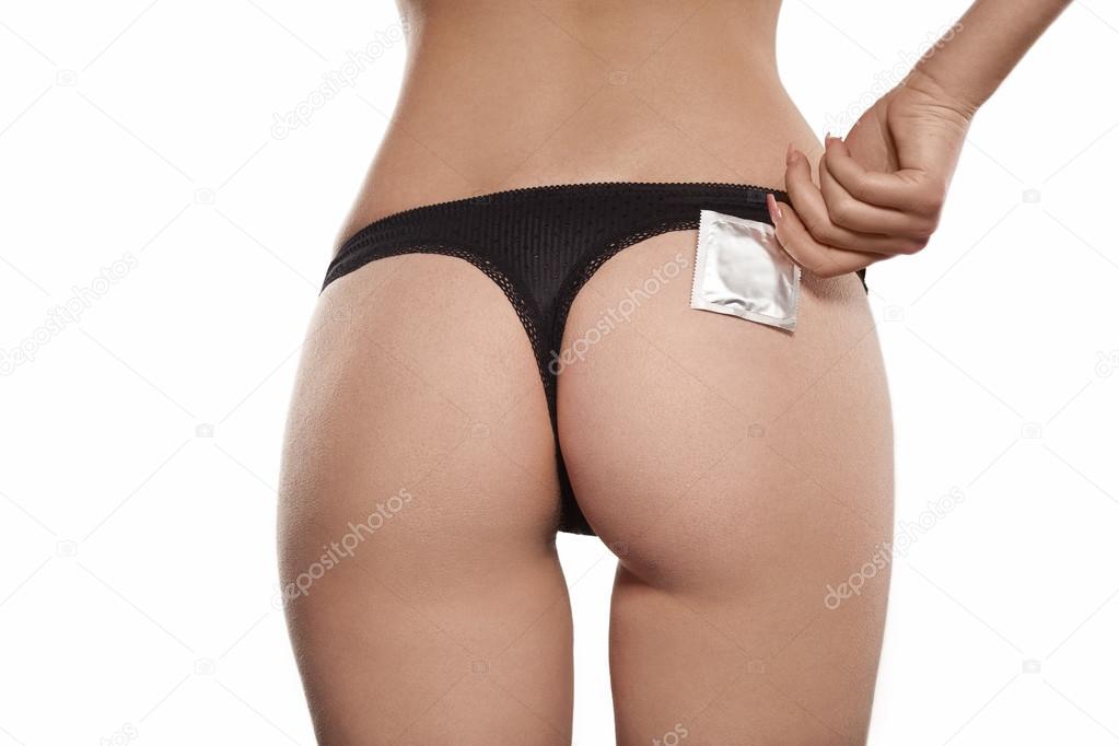 Condom near sexual ass of young beautiful woman, black thong, be Stock Photo by ©Max5799 69760639