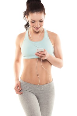 Fitness kız beyaz bir arka plan üzerinde bir akıllı telefon ile hoşlanır spo