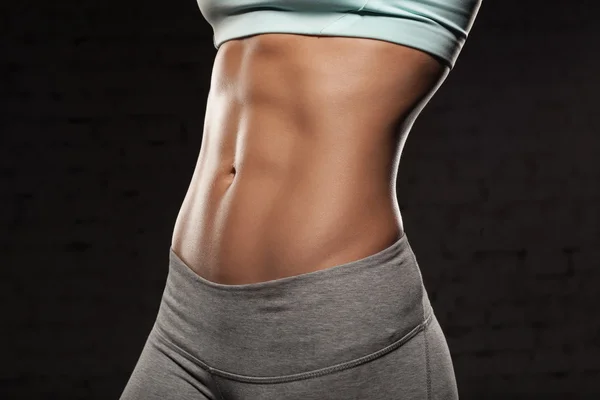 Wanita fit dengan tubuh berotot, melakukan latihan, abs, perut Stok Foto