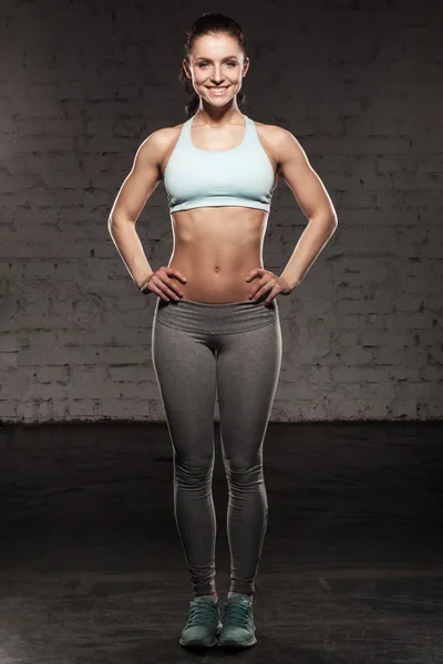 Спортивна жінка з прекрасною посмішкою, фітнес-жінка з м'язовим тілом, роблять її тренування, черевні пороки — стокове фото