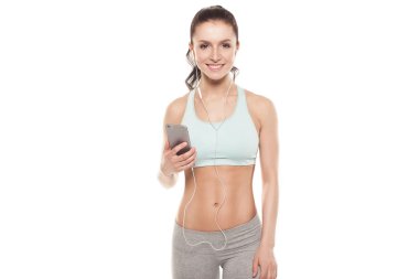 Beyaz arka planda akıllı telefonu olan fitness kızı spor antrenmanlarını, spor antrenmanlarını seviyor.