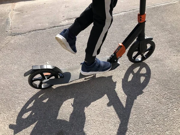 Bacaklar ve scooter asfaltta yakın plan. — Stok fotoğraf