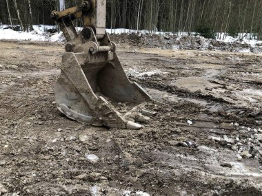 Kazıcı toprağı kazıyor, baharda yolu gün boyunca onarıyor..