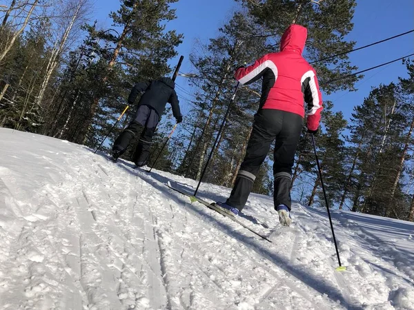 Moeder en zoon beklimmen de berg op ski 's. — Stockfoto