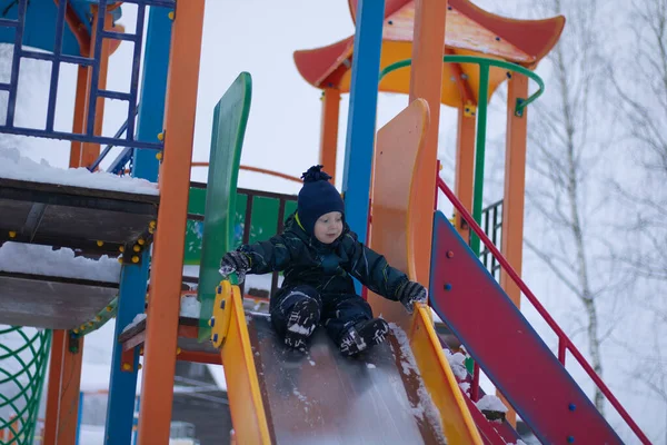 Bir Çocuk Kışın Oyun Parkında Kayar Karlı Bir Kış Parkında — Stok fotoğraf