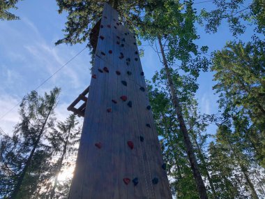 Özel tırmanma çıkıntılarının sabitlendiği yüzey kayanın rahatlatmasını taklit ediyor. Dışarıdaki tırmanma duvarı.