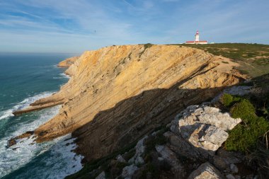 Cabo Espichel pelerini, günbatımında Portekiz 'deki deniz kayalıkları ve Atlantik okyanus manzarasıyla birlikte.