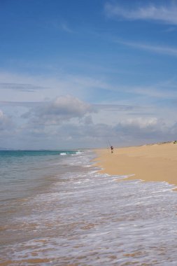 Portekiz 'de kumsalda okyanus dalgaları olan Comporta' da balık tutan bir balıkçı.