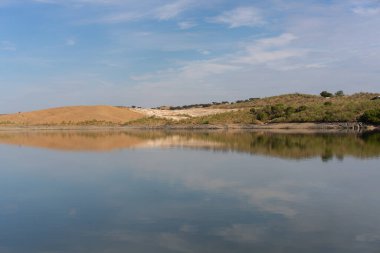 Portekiz, Terena 'da mavi gökyüzü olan baraj gölü rezervuarındaki suya yansıyan tepe manzarası gibi çöl.