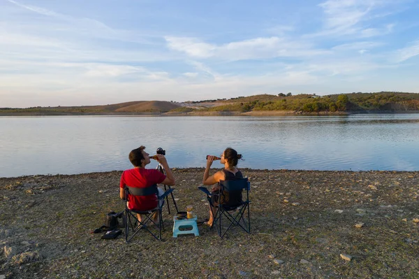 Pareja Caucásica Sienta Sillas Lago Bebiendo Cerveza Viendo Paisaje Alentejo — Foto de Stock