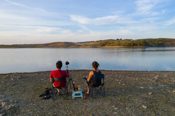 Pareja Caucásica Sienta Sillas Lago Bebiendo Cerveza Viendo Paisaje Alentejo — Foto de Stock