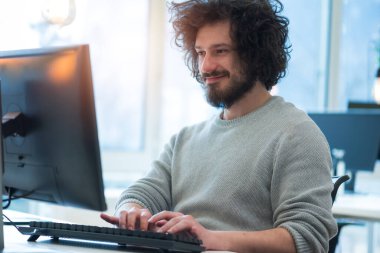 Modern ofisinde dizüstü bilgisayarla çalışan ciddi bir yönetici..