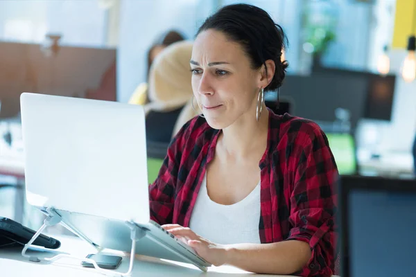 Focused young female CEO leader sitting at table, holding online meeting with coworkers during corona season. tay home, study and work online, quarantine coronavirus