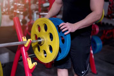 Çekirdek Vücut Geliştirme. Kas geliştiren vücut geliştirici beden eğitimi modeli. Spor salonunda dambılları olan kollar. Spor salonundaki egzersizlerin konsept fotoğrafı