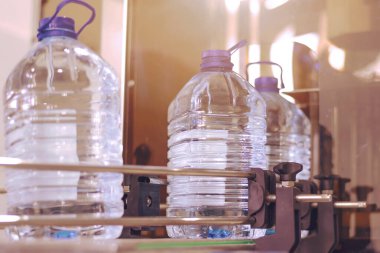 Şişeleme tesisi - Su şişeleme hattı saf kaynak suyunu işlemek ve şişelemek için mavi şişelere. Seçici odak.
