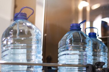 Şişeleme tesisi - Su şişeleme hattı saf kaynak suyunu işlemek ve şişelemek için mavi şişelere. Seçici odak.