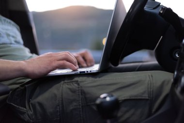 Mobil araba servis mühendisi yolda dizüstü bilgisayarıyla arabayı kontrol ediyor. Yol yardımı kavramı