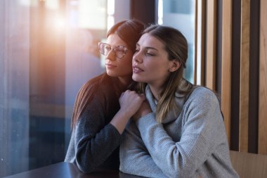 LGBT neşeli bayan arkadaşları kafede sohbet ediyorlar. Birlikte olmaktan zevk alan iki güzel genç kadın. Arkadaşlık, gay, LGBT ve aşk konsepti.