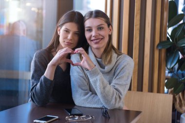 LGBT neşeli bayan arkadaşları kafede sohbet ediyorlar. Birlikte olmaktan zevk alan iki güzel genç kadın. Arkadaşlık, gay, LGBT ve aşk konsepti.