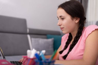 Evde online okul dersi alan genç bir kız. Evde eğitim görüyorum. Coronavirus zamanlarında evden öğreniyorum..