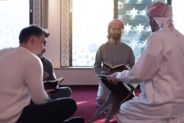 Bir grup dindar Müslüman genç insan birlikte Kur 'an okuyup dua ediyor. Camide namaz kılan bir grup müslüman..