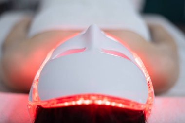 Foton maskesi. Sağlık ve güzellik. Kadın yüzü için estetik ameliyat. Güzellik laboratuarı. LED Yüz Maskesi, Foton Terapisi. Fotoğraf farklı kipleri, renkleri gösterir