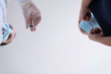 Klinikteki pratisyen hekimin aşısı. Doktor, hastanede yaşlı kadına iğne yapıyor. Covid-19 ya da Coronavirus aşısı yapmadan önce elinde şırınga tutan hemşire..