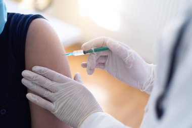 Koluna grip aşısı, koronavirüs aşısı, covid-19 aşısı aşısı aşısı yapılan bir hastanın omzuna aşı yapan bir doktor hastaya yakından bakın..