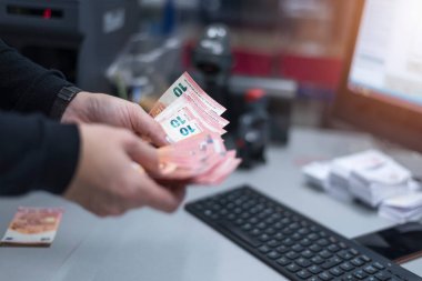 Banka çalışanları banka kasasında para sayıyor ve sıralıyor. Bankada büyük miktarda para var..