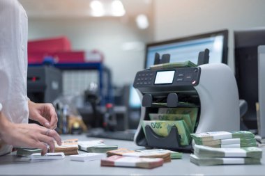 Banka çalışanları banka kasasında para sayıyor ve sıralıyor. Bankada büyük miktarda para var..