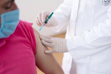 Klinikte salgını, gribi ya da grip virüsünü önlemek için aşı yapan bir doktor.