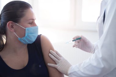 Klinikte salgını, gribi ya da grip virüsünü önlemek için aşı yapan bir doktor.