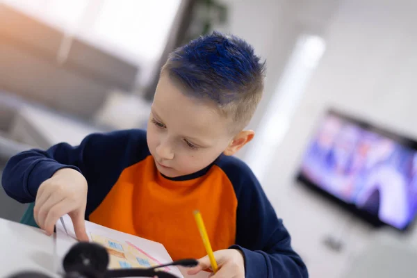 Distance learning and online education. Schoolboy boy studies at home and does school homework. Remote learning during corona pandemic