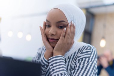 Stresli Afro-Amerikalı Müslüman iş kadını uzun dizüstü bilgisayar kullandıktan sonra yorgun ve üzgün