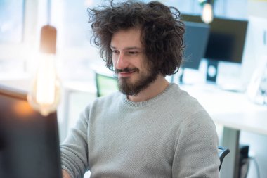 Yaratıcılık alanında çalışan genç bir adam. Modern çalışma alanının içinde yeni yaratıcı dijital projeler üzerinde çalışıyoruz..