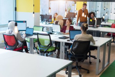 Modern açık alan ofisinde birlikte çalışan yaratıcı, çok ırklı iş adamları grubu.