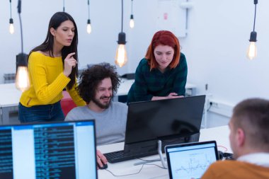 Modern açık alan ofisinde birlikte çalışan yaratıcı, çok ırklı iş adamları grubu.