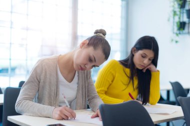Bir grup insan sunum konuşmasını dinliyor ve yaratıcı ofiste birlikte çalışıyor ve iletişim kuruyorlar.