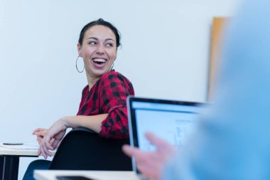 Bir grup insan sunum konuşmasını dinliyor ve yaratıcı ofiste birlikte çalışıyor ve iletişim kuruyorlar.